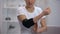 Woman applying elbow padded orthosis, feels pain after sport injury, orthopedics