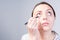 Woman Applying Eyeliner Makeup While Looking Up