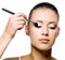 Woman applying eyeshadow with brush