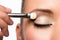 Woman applying eyeshadow on eyelid