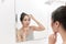 Woman applying face cream after daily shower. Making everyday morning routine in bathroom