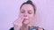 Woman is applying fresh homemade coconut scrub on the face from coconut shell.