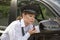 Woman applying lipstick looking in car wing mirror