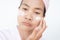 Woman applying lotion skin serum cream on face with slack face because problem insomnia. Moisturizer skin care for moisturized