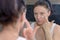 Woman applying a moisturising cream to her cheek