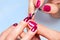 Woman applying nail varnish to finger nails