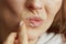 Woman applying ointment using finger isolated on beige