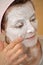 Woman applying pearl powder mask