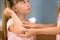 Woman applying plaster on girl`s elbow indoors