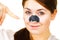 Woman applying pore strips on nose