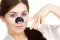 Woman applying pore strips on nose