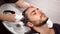 Woman applying shampoo massaging hair customer man wash hair in beauty salon hairdresser washing hair. Happy caucasian