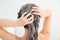 Woman applying shampoo onto her hair