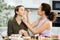 Woman applying soft shade of eyeshadow to friend eyelids