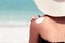 Woman applying sunscreen creame on  tanned  shoulder. Skincare. Sun protection sun cream. Bikini hat woman applying sunscreen loti