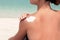 Woman applying sunscreen creme on  tanned  shoulder. Skincare. Body Sun protection suncream.