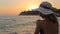 Woman applying sunscreen to her shoulder on a warm near the sparkling sea