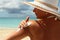 Woman applying Suntan Lotion at the beach