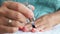 Woman applying transparent nail lacquer on nails while home manicure. Woman polishing nails close up. Home manicure and