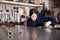 Woman apprentice measures metal sheet with tape measure