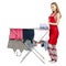 Woman in apron clothes drying rack with clean clothes stack towels