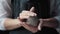 Woman in an apron holds white clay in hands and warms it in palms