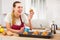 Woman in apron tasting freshly baked sweet cupcakes in kitchen