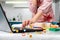 A woman in an apron uses a laptop on the kitchen table. Emoji icons fly in the air. Close up. The concept of live video