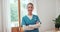 Woman, arms crossed and face of nurse working in living room of nursing home. Happy, caregiver and portrait with