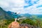 Woman with arms outstretched conquering mountain top at Nong Khiaw Nam Ou River valley Laos mature people traveling millenials