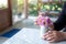 A woman arranging beautiful pink flowers in a white small vase