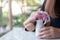 Woman arranging beautiful pink flowers in a white small vase on the table