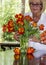 Woman arranging bouquet of colorful tulips.