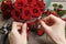 Woman arranging bouquet of red roses