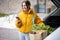 Woman arrives home by car with a groceries