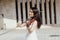 Woman artist with dark hair in a dress plays a wooden concert electric violin