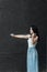 Woman artist with dark hair in a dress plays a wooden concert electric violin