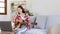 Woman artist playing the guitar and live or stream on laptop in the living room