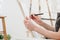 Woman artist`s hand with a large simple pencil, draws on a clean white canvas, close-up.