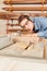 Woman as a carpenter apprentice saws a board