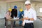 Woman as Foreman wear Yellow Hardhat holding Blueprint Standing