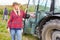 Woman as harvesting assistant on tractor in vineyard