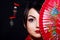 Woman in Asian costume with red Asian fan