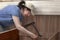 Woman assembles furniture, hinges lifting mechanism screwed to b