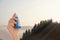 Woman with asthma inhaler and mountains on background, closeup. First emergency medical aid