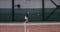 A woman athlete plays tennis, deftly repulsing blow after blow with a racket