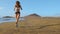 Woman athlete silhouette running on beach sprinting waves crashing on seaside morning background slow motion