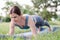 Woman athlete stands in the plank. Sports activities in nature. Woman doing sports exercise in the park