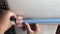 A woman attaches a mop to a wall holder. vertical video. Close-up