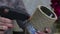 A woman attaches a rope to a tin can with a glue gun. Crafts in self-isolation. Close-up shot